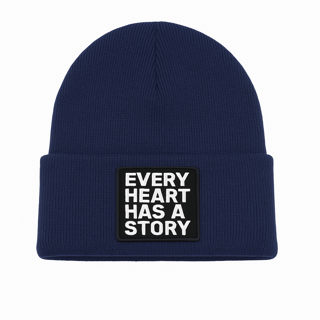 Navy blue beanie with 'Every Heart Has a Story' patch on a white background
